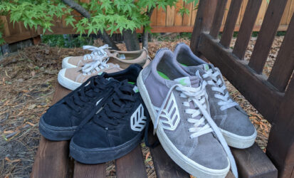 Three pairs of Cariuma sneakers on a chair in front of a maple tree